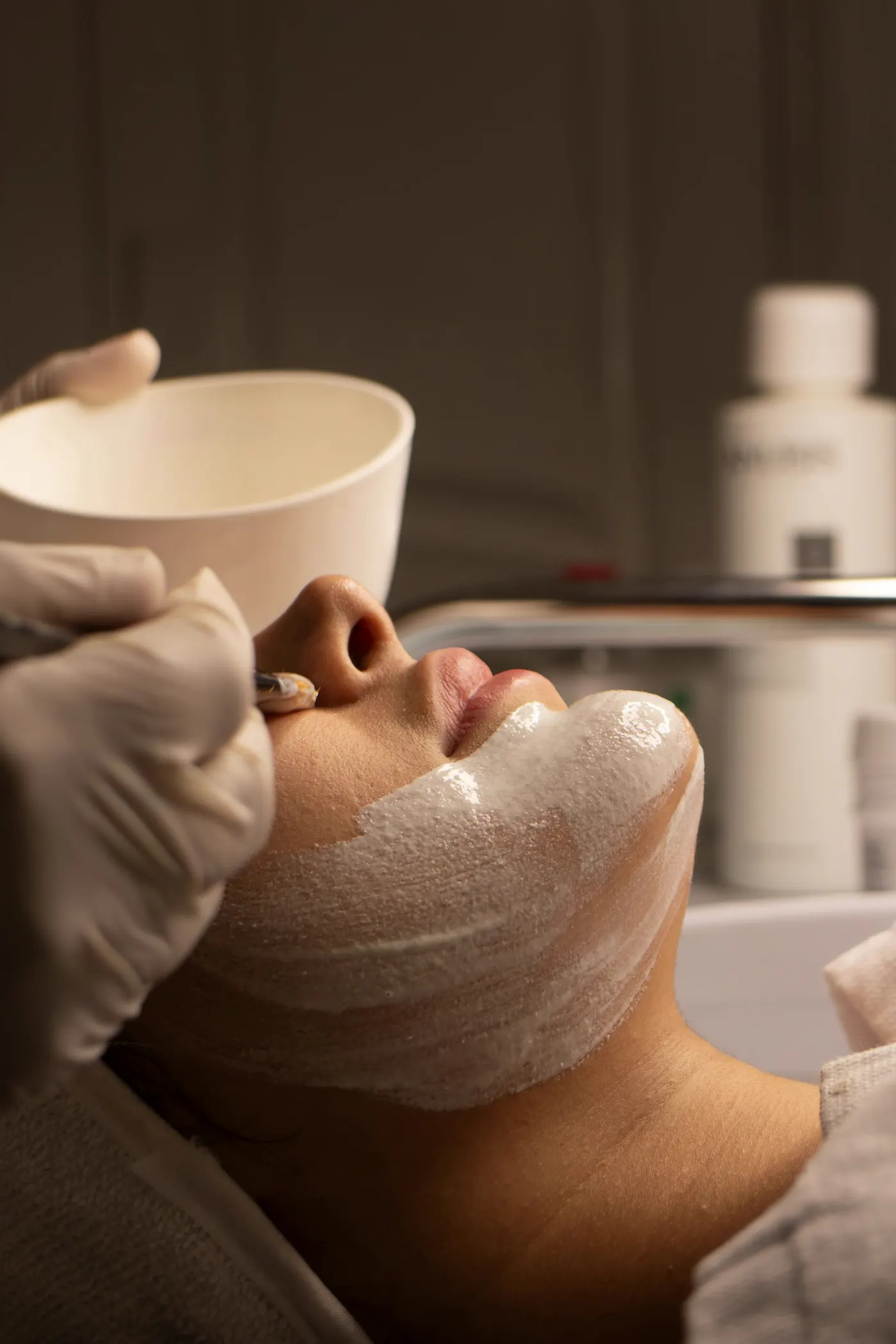 Tratamiento facial con mascarilla aplicada con guantes