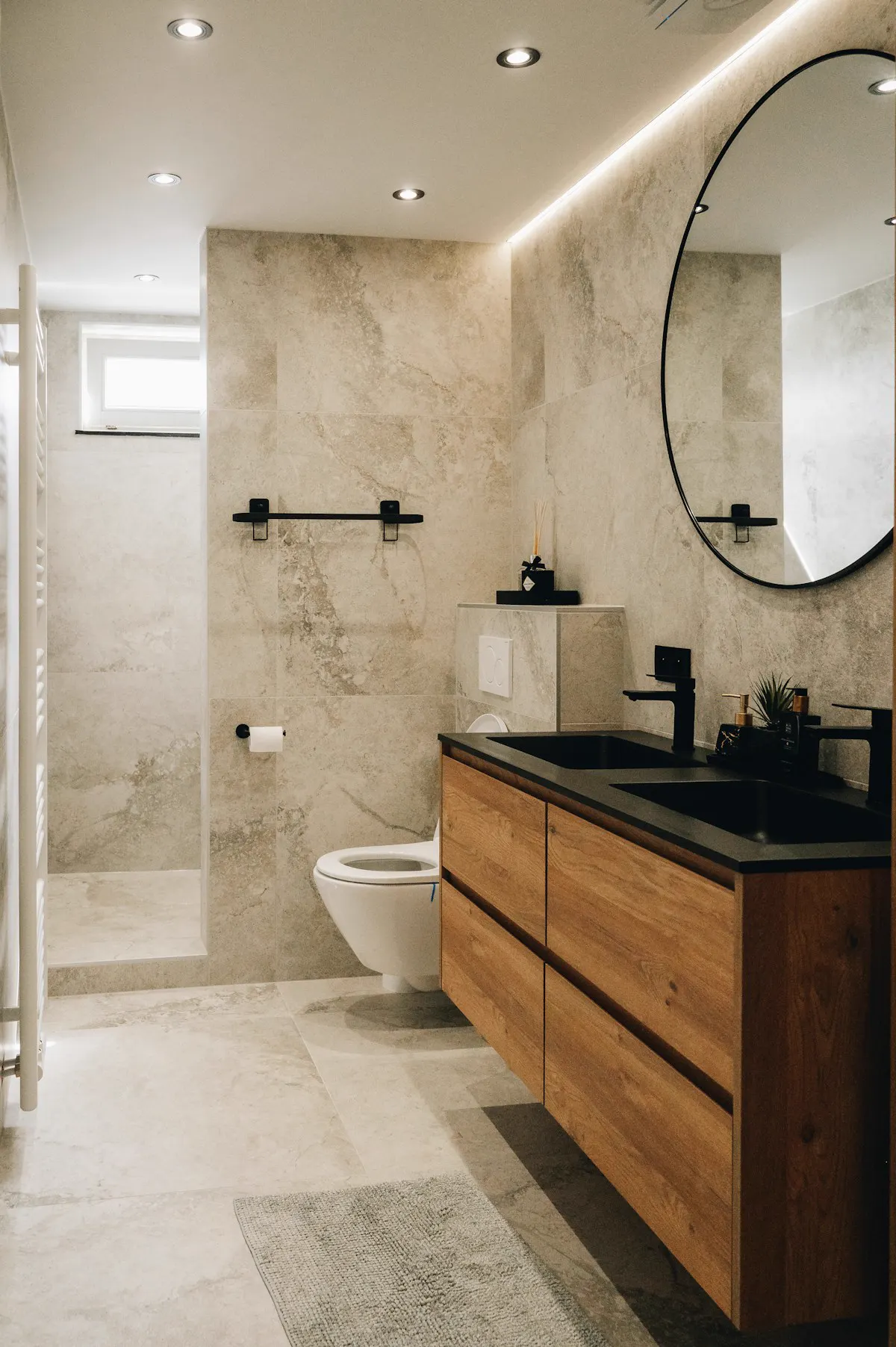 Baño con mueble de madera, lavabo negro y ducha de obra