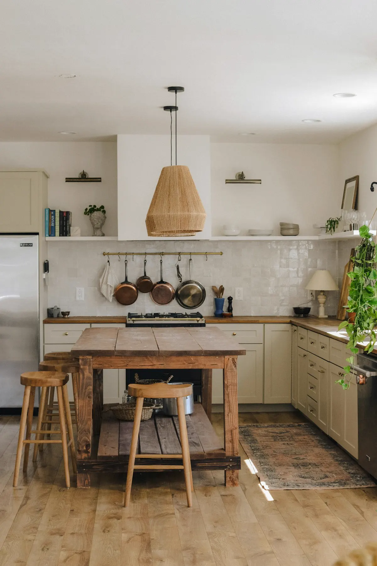 Cocina abierta con isla de madera y lámpara de mimbre