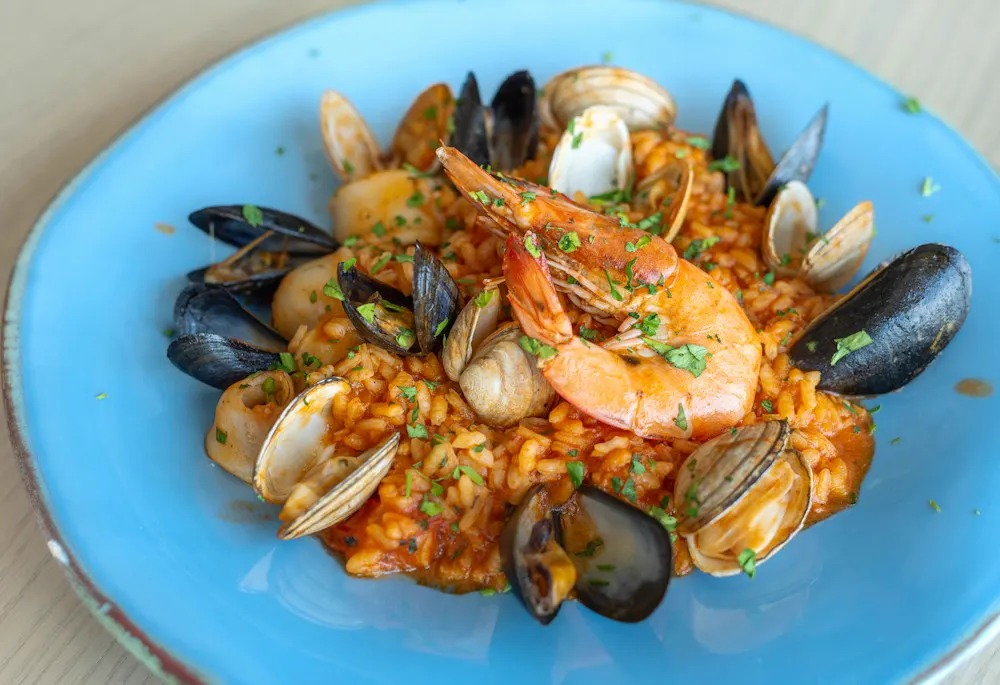 Arroz meloso de marisco en plato azul