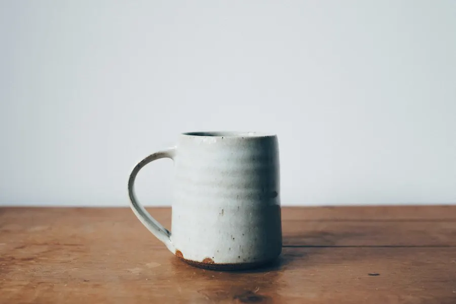 Taza blanca de cerámica sobre una mesa de madera