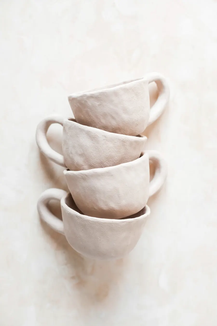 Cuatro tazas de cerámica rosada apiladas