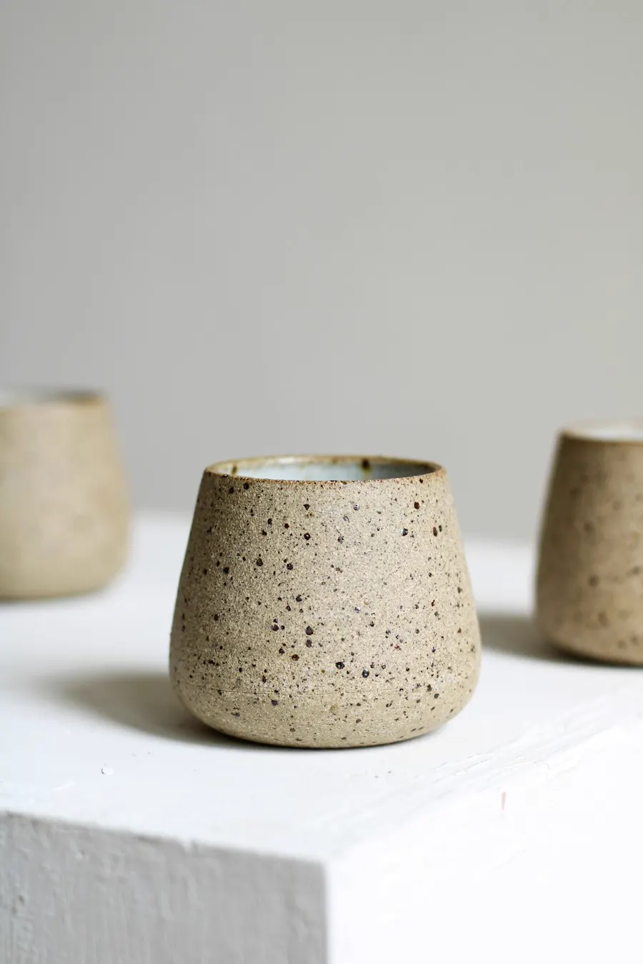 Vaso de gres moteado sobre mesa blanca